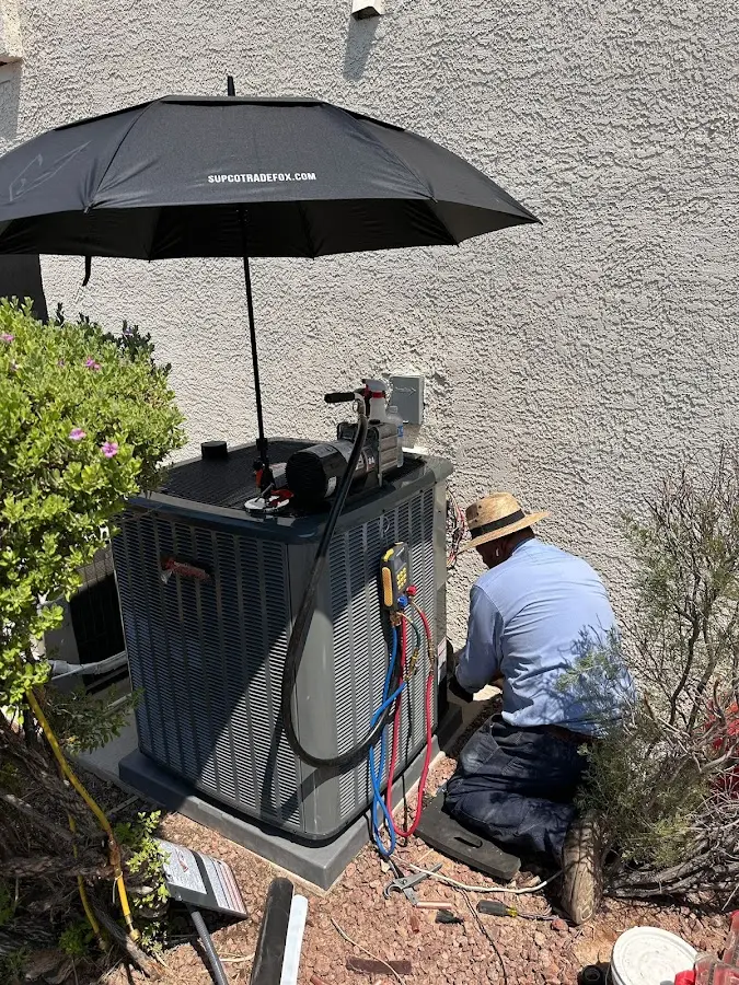 HVAC technician performing outdoor AC maintenance in Estes Park