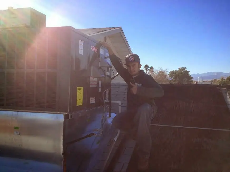 HVAC technician performing Heat Pump Repair on a rooftop unit in Estes Park